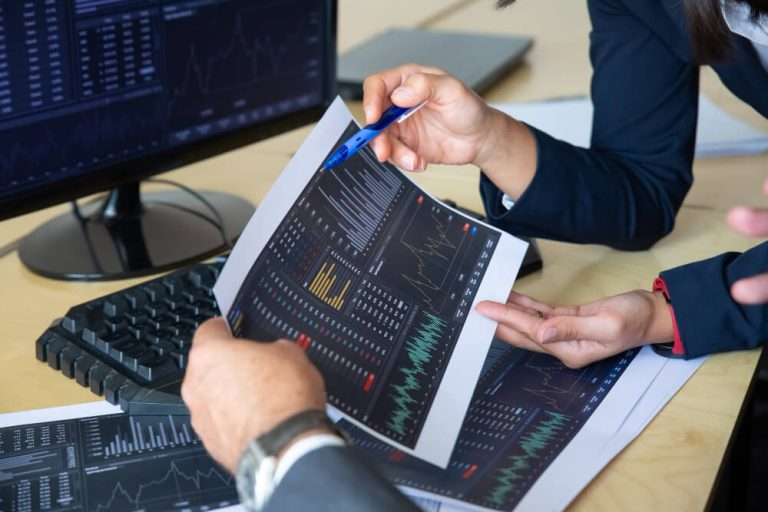 brokers discussing trading strategy holding papers with financial data pointing pen charts cropped shot broker job stock market exchange concept 1